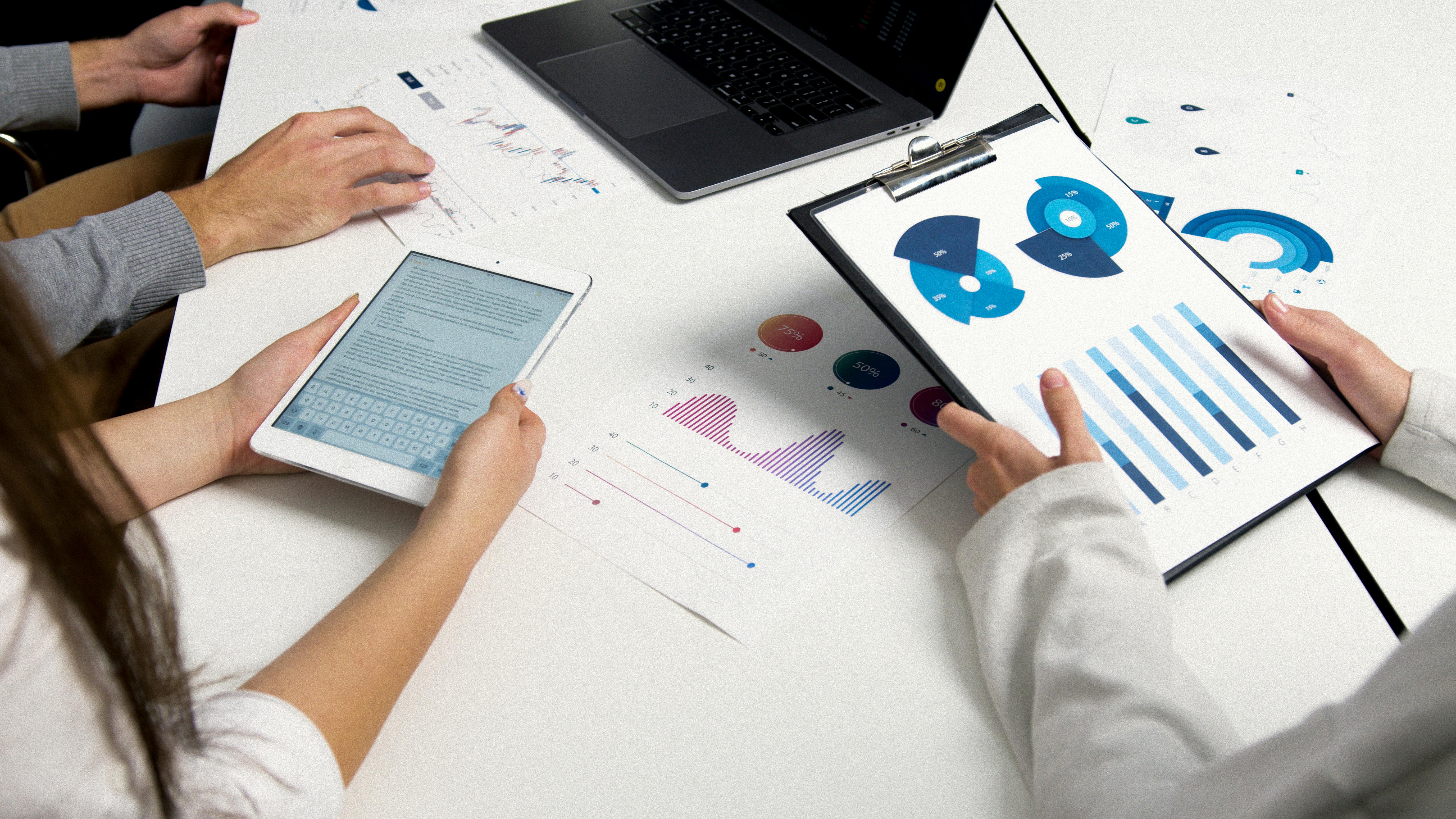 people gathered around a table full of graphs